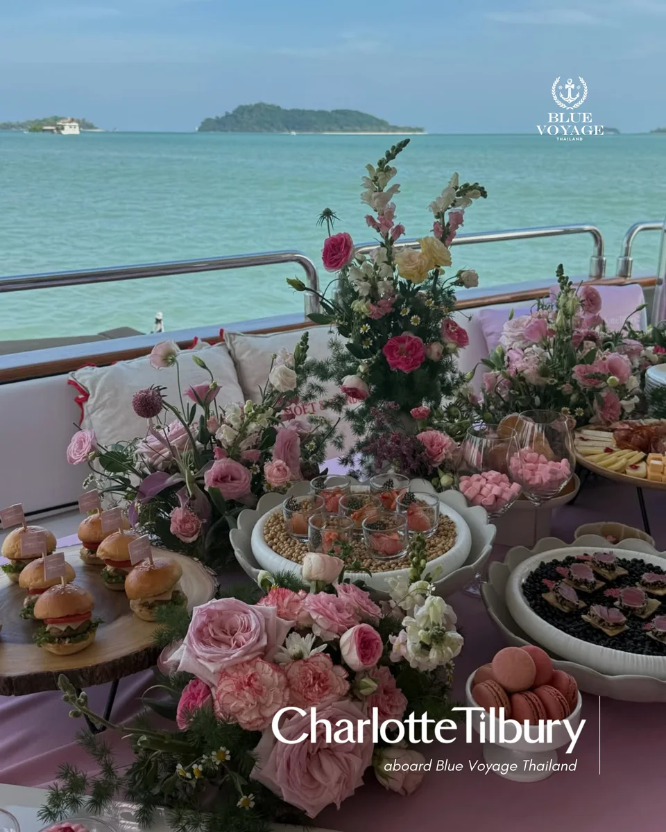 Pink flowers and table decorations for a Charlotte Tilbury event beside the water
