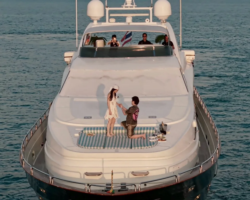 A couple celebrating a proposal on the yacht's foredeck